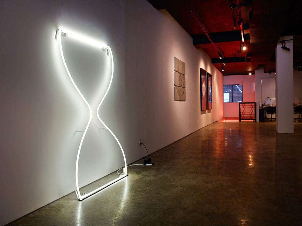 Wall sculpture of neon hourglass, cement relief wall sculpture and zoe buckman photography on display at Garis &amp; Hahn Gallery in New York City.