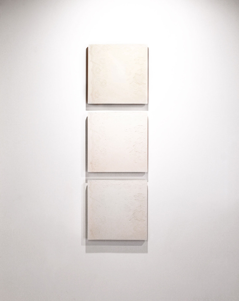 Modern wall art: feminine design shown through relief juxtaposed on concrete tile.