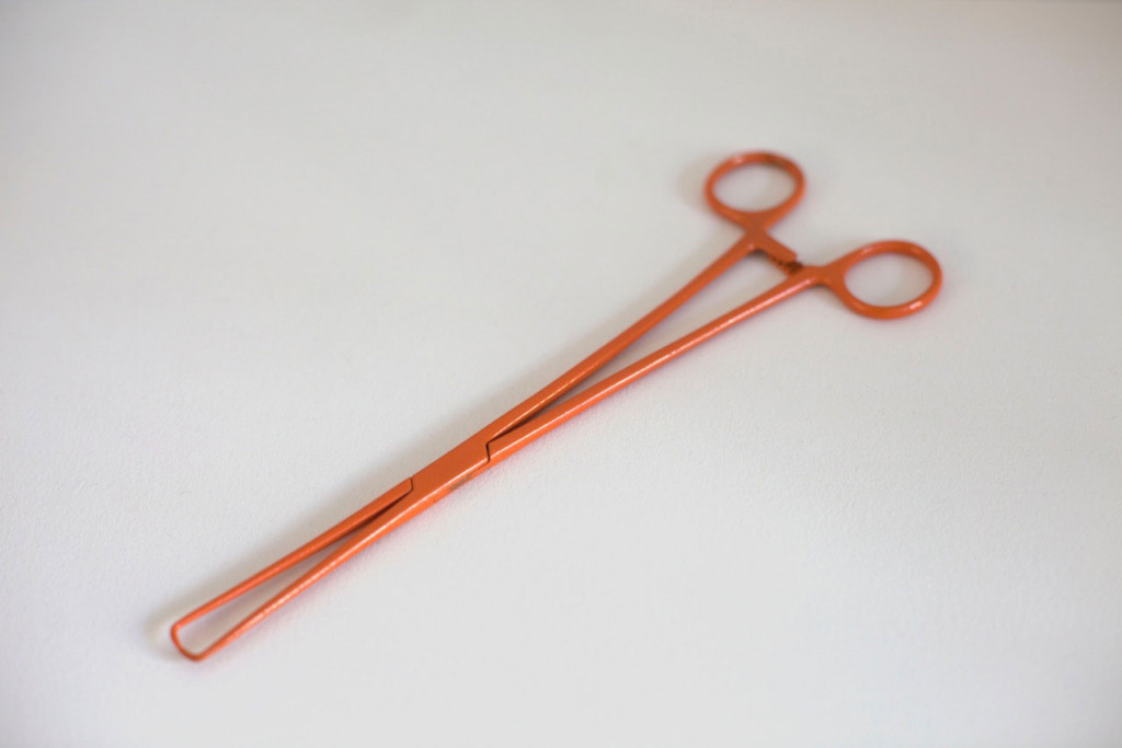 Bright orange powder coated gynecological instrument sculpture by New York feminist artist Zoe Buckman