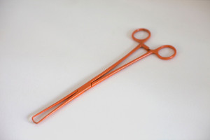 Orange powder coated gynecological instrument sculpture by feminist artist Zoe Buckman